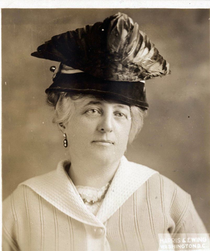 Minnie Brook portrait. She is wearing a large triangular hat.