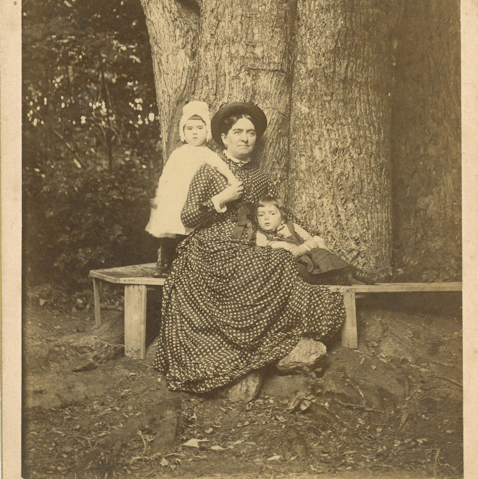Mary Bentley Thomas sitting on a bench in front of a tree