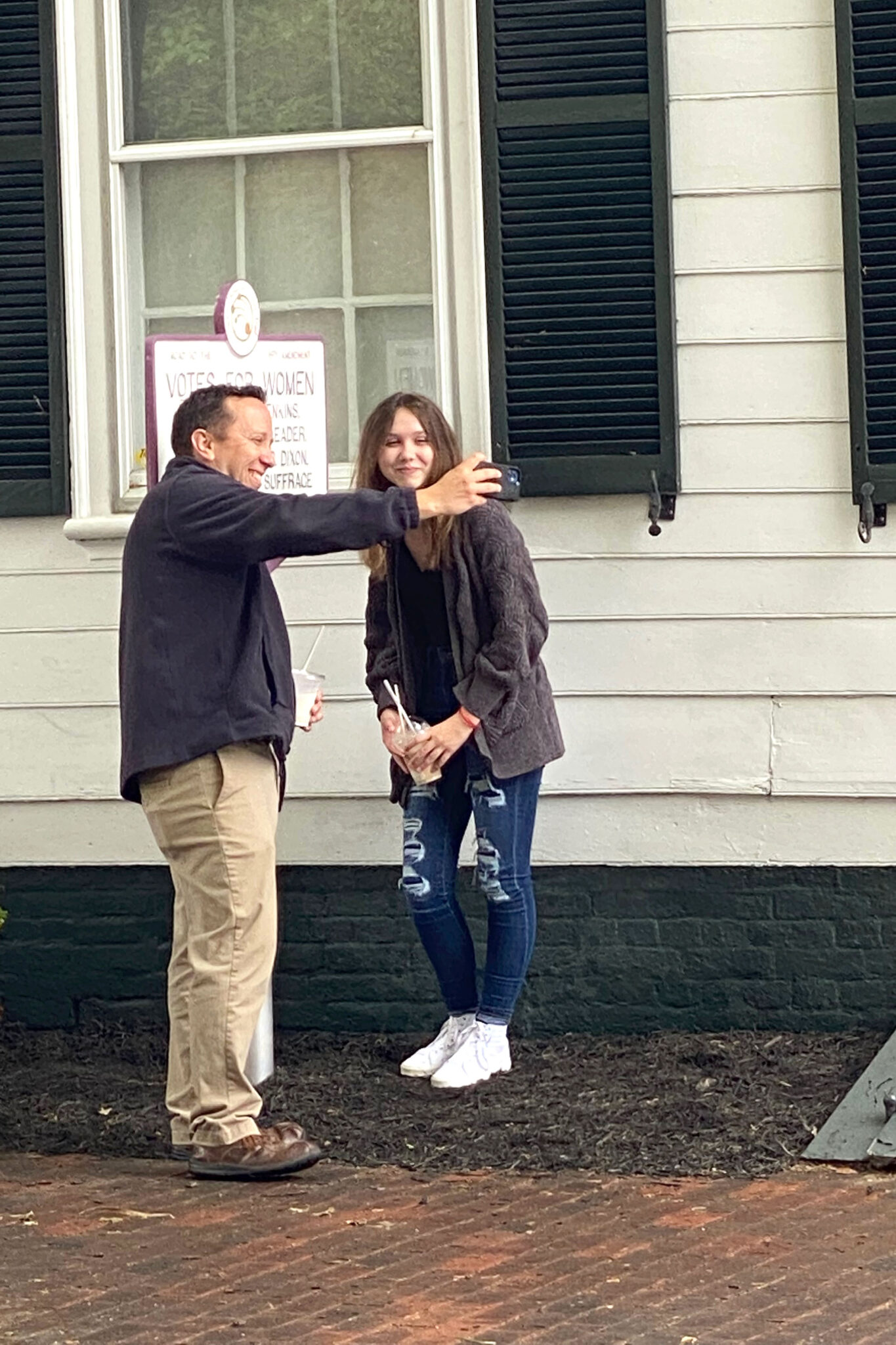 A dad and daughter taking a selfie at the suffrage marker in Easton