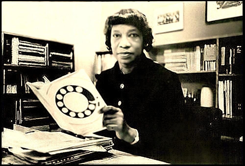 A sepia tone photo of Dr. Williams holding her book Equal Employment Opportunity and the AT&T Case