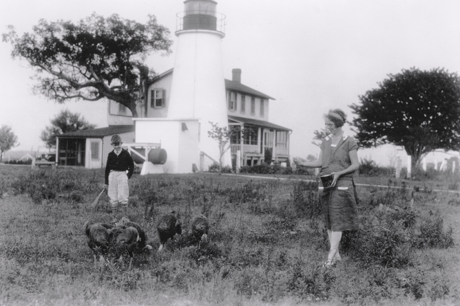 Turkey Point Light historical photo with two people gardening on the lawn