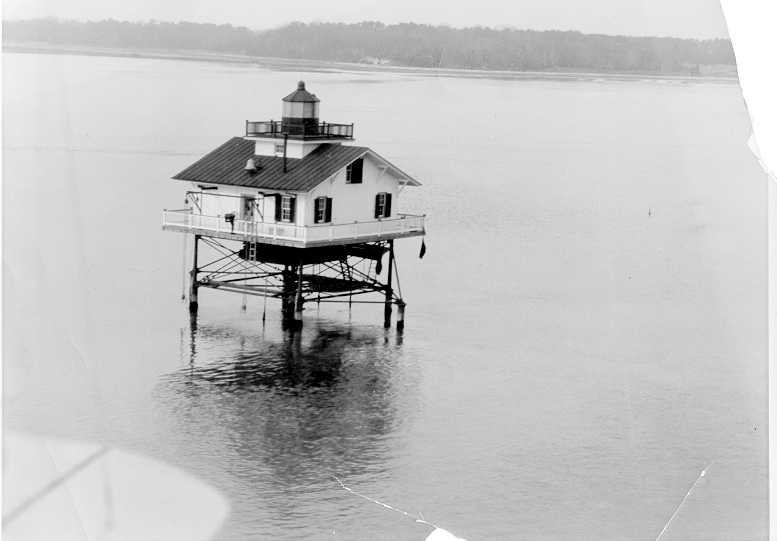 UpperCedarPoint Lighthouse on tilts in water.<br />