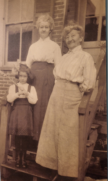 Helen Tune edited small A sepia tone photo of Helen Tune, her Daughter and granddaughter. All are wearing long skirts and white long-sleeve blouses.