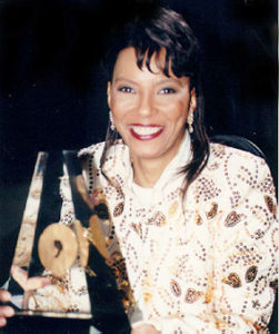 Black woman smiling for camera wearing print jacket