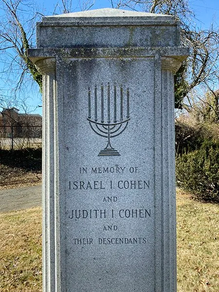 a memorial gravestone with a menorah that says in memory of Judith and Isreal Cohen and their descendants